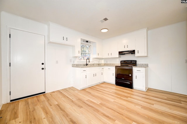 kitchen with electric range, white cabinetry, and light hardwood / wood-style floors