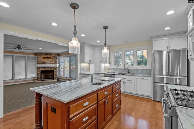 kitchen featuring white cabinetry, light wood-type flooring, stainless steel appliances, and a center island