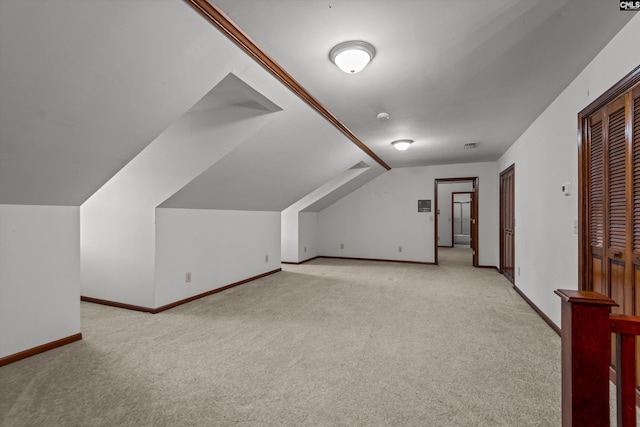 bonus room with light colored carpet and vaulted ceiling