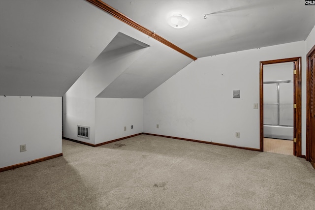 bonus room featuring light colored carpet and vaulted ceiling