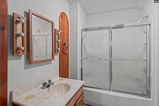 bathroom featuring combined bath / shower with glass door and vanity