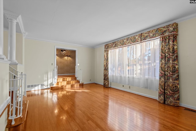 unfurnished living room with ornate columns, crown molding, and hardwood / wood-style floors