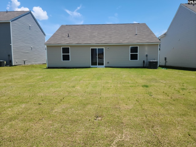 back of house featuring central AC and a yard