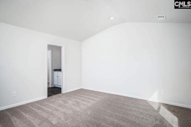 unfurnished room featuring carpet and lofted ceiling