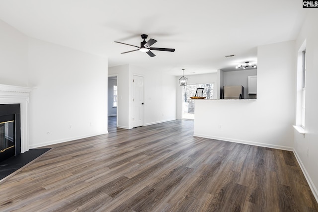 unfurnished living room with dark wood-type flooring and ceiling fan