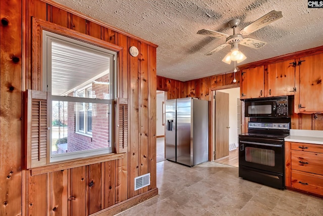 kitchen with ceiling fan, wood walls, and black appliances