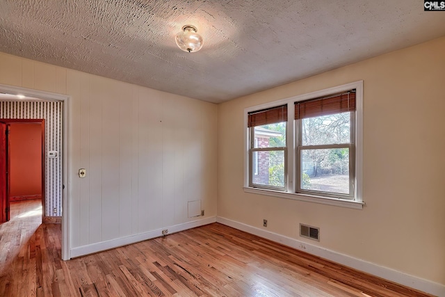 empty room featuring light hardwood / wood-style floors and a textured ceiling