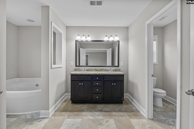 bathroom featuring toilet, a tub, and vanity