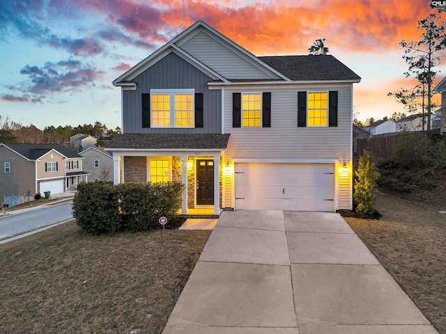 traditional-style house with a garage, driveway, board and batten siding, and a front yard