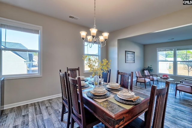 dining area with hardwood / wood-style flooring and a chandelier