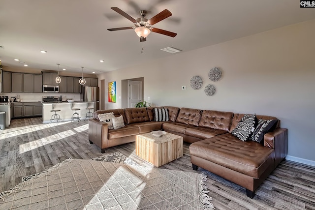 living room featuring ceiling fan and dark hardwood / wood-style floors