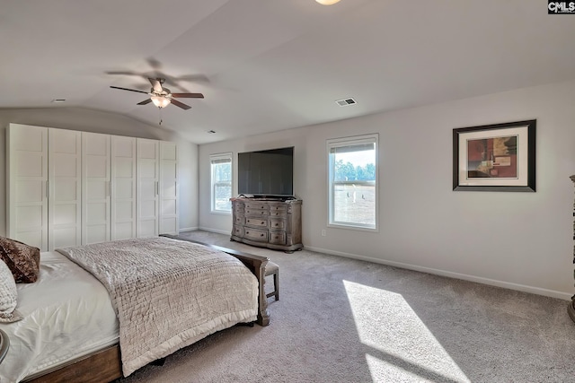 bedroom with ceiling fan, light colored carpet, a closet, and vaulted ceiling