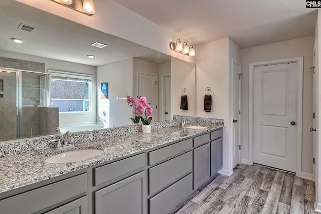 bathroom featuring vanity, plus walk in shower, and hardwood / wood-style floors