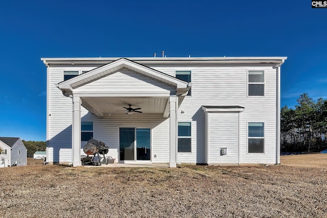 back of house with ceiling fan and a lawn