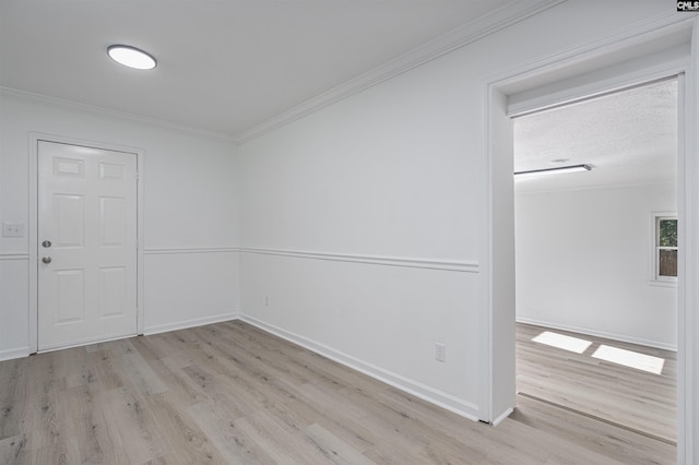 unfurnished room featuring ornamental molding and light wood-type flooring