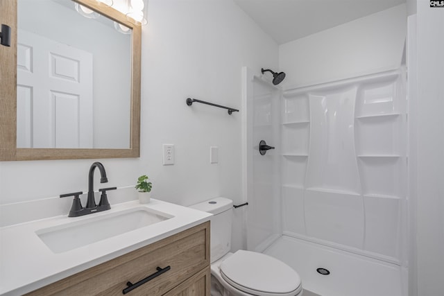 bathroom with toilet, walk in shower, and vanity