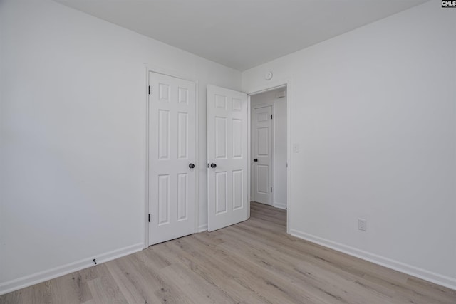 unfurnished bedroom with a closet and light hardwood / wood-style flooring