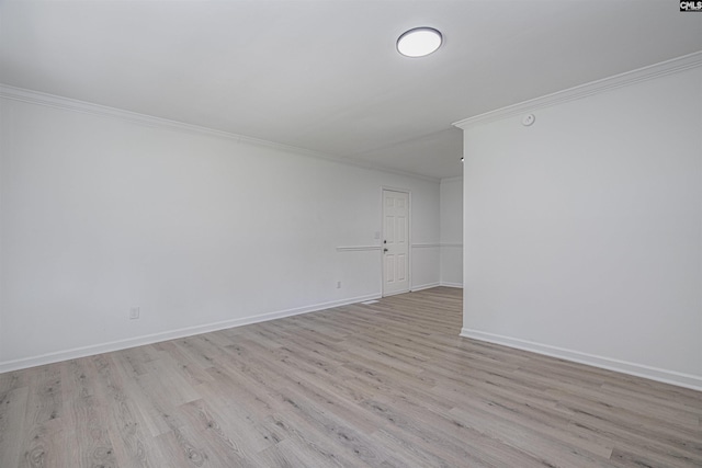 empty room featuring light wood-type flooring and ornamental molding