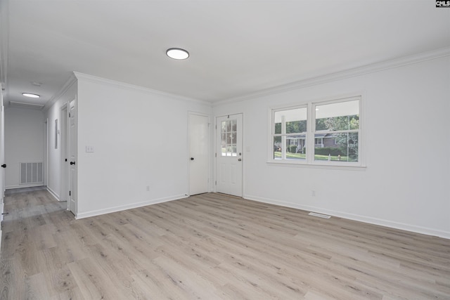 spare room with crown molding and light wood-type flooring