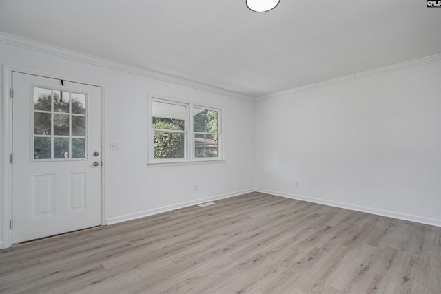 entrance foyer with ornamental molding and light hardwood / wood-style flooring