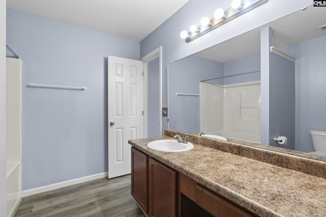 bathroom with hardwood / wood-style flooring, toilet, and vanity