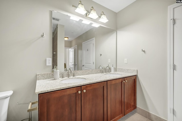 bathroom with toilet, tile patterned flooring, and vanity