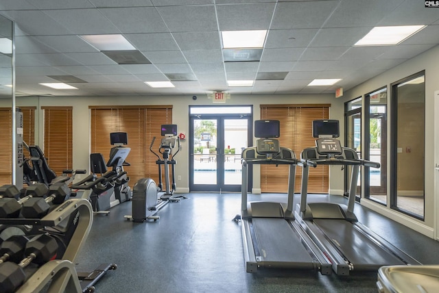 workout area with a paneled ceiling and french doors