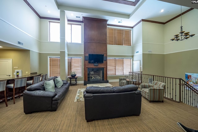 carpeted living room with a fireplace, a towering ceiling, and plenty of natural light