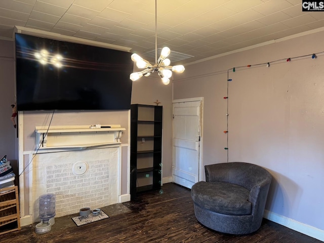 sitting room featuring an inviting chandelier, ornamental molding, and dark hardwood / wood-style floors