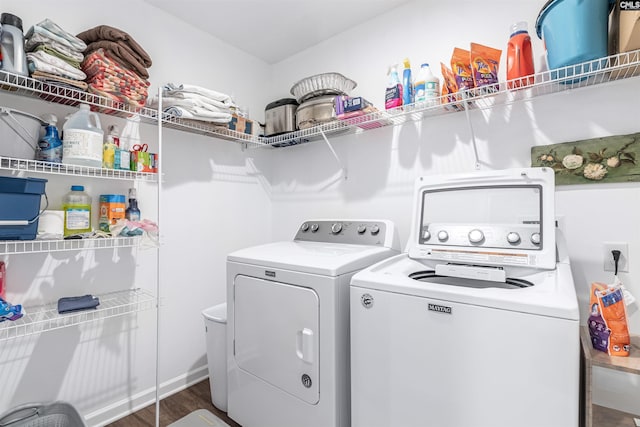 clothes washing area featuring dark wood-type flooring and washing machine and clothes dryer