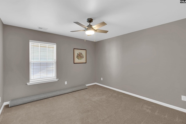 carpeted spare room featuring ceiling fan