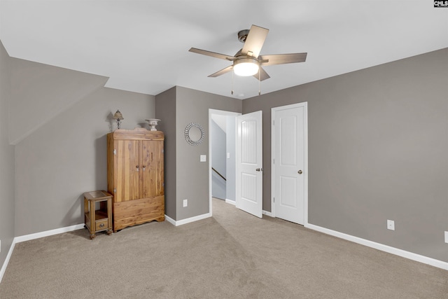 unfurnished bedroom with ceiling fan and light colored carpet