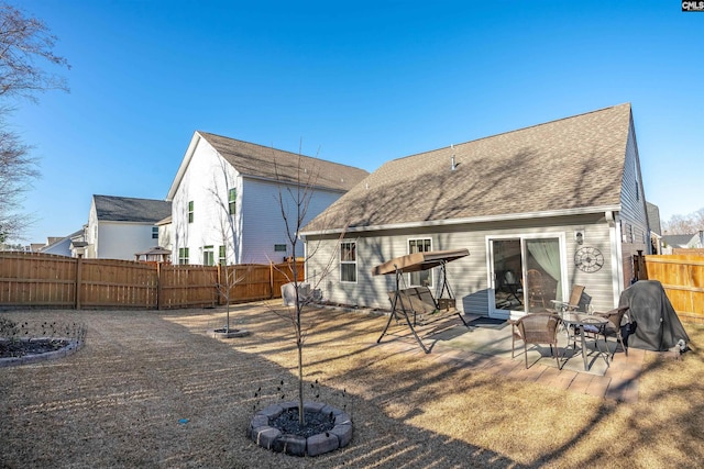 rear view of property featuring a patio and a fire pit