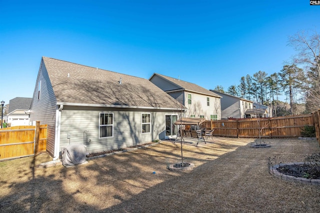 rear view of property featuring a hot tub, a fire pit, and a patio