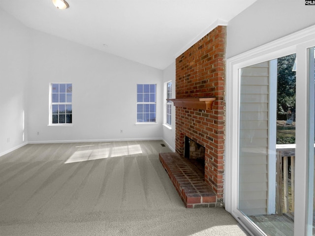 unfurnished living room featuring vaulted ceiling, a brick fireplace, and light colored carpet