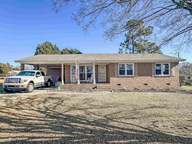 ranch-style house with a front lawn, a porch, and a carport