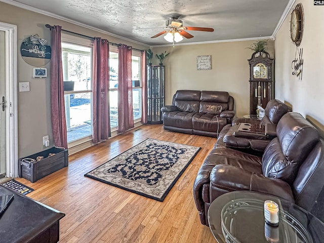 living room featuring wood-type flooring, ornamental molding, and ceiling fan