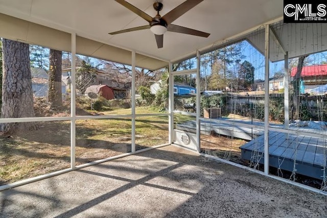 unfurnished sunroom featuring ceiling fan and a healthy amount of sunlight