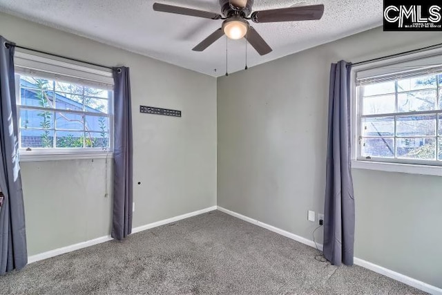 carpeted spare room featuring a textured ceiling and ceiling fan