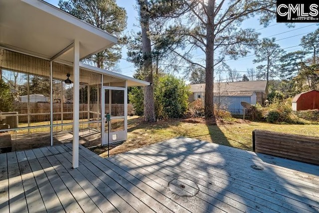 wooden terrace with a sunroom and a lawn