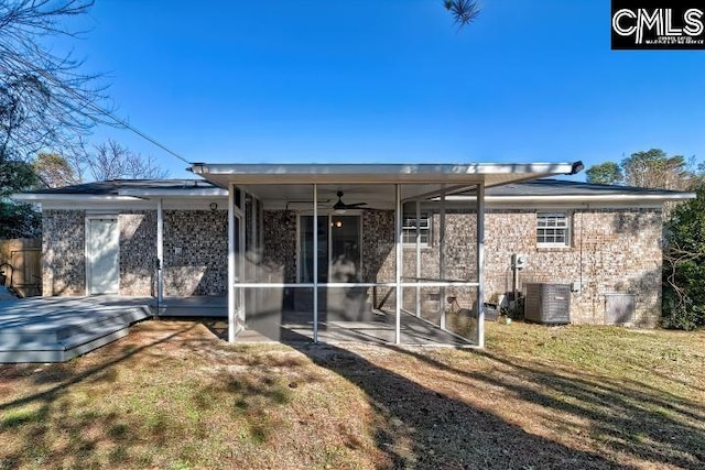 back of property with ceiling fan, a yard, a sunroom, and central AC