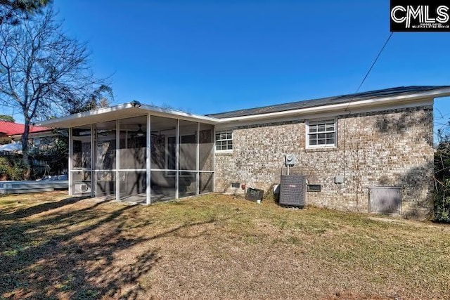 back of house with a sunroom, a yard, and central air condition unit