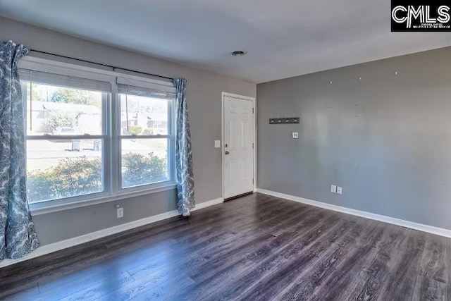 unfurnished room featuring a wealth of natural light and dark hardwood / wood-style flooring