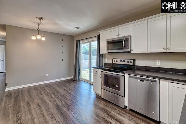 kitchen featuring appliances with stainless steel finishes, white cabinetry, and pendant lighting