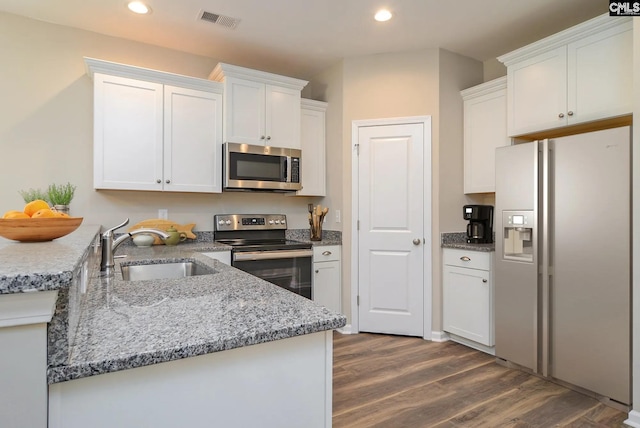 kitchen featuring light stone countertops, white cabinets, stainless steel appliances, sink, and dark hardwood / wood-style floors