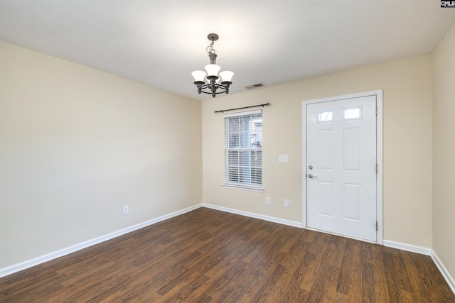 entryway featuring dark wood-type flooring and a notable chandelier