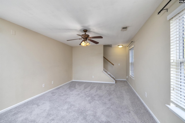 carpeted spare room with ceiling fan