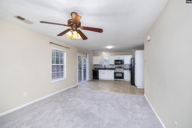 kitchen featuring light carpet, white cabinetry, ceiling fan, tasteful backsplash, and black appliances