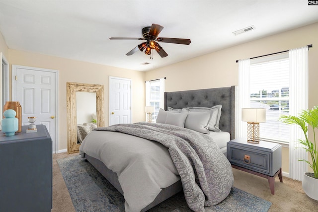 bedroom with ceiling fan, carpet floors, and multiple windows