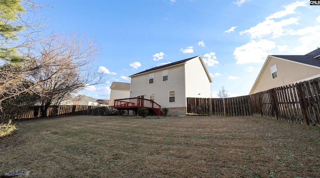 rear view of house with a deck and a yard